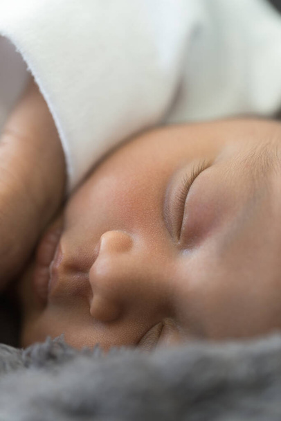Close up to face of beautiful sleeping brunette baby, studio - Фото, изображение