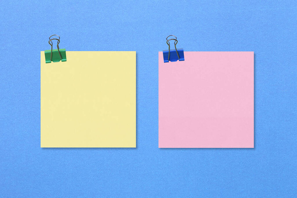 Kleurrijke vierkante nota papier op blauw papier achtergrond en hebben kopieerruimte voor u ontwerp. - Foto, afbeelding