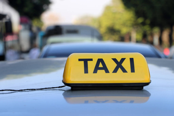 Taksi valo merkki tai ohjaamon merkki keltainen väri musta teksti auton katolla kadulla hämärtynyt tausta, Myanmar. - Valokuva, kuva