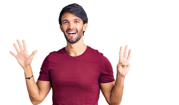 Hezký hispánský muž na sobě ležérní oblečení ukazuje a ukazuje s prsty číslo osm a zároveň se usmívá sebevědomě a šťastně.  - Fotografie, Obrázek