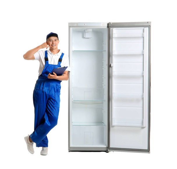 Trabalhador de serviço de reparação perto da geladeira no fundo branco - Foto, Imagem