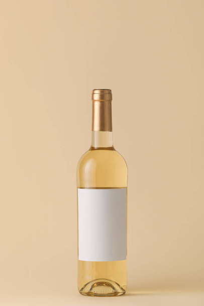 色の背景にブランクラベルのワインのボトル。デザインのためのモックアップ - 写真・画像
