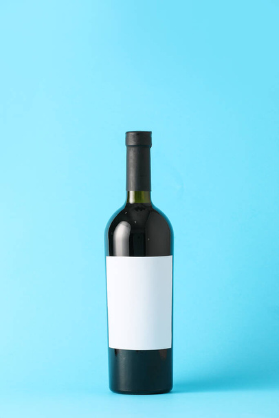 Bottle of wine with blank label on color background. Mockup for design - Φωτογραφία, εικόνα