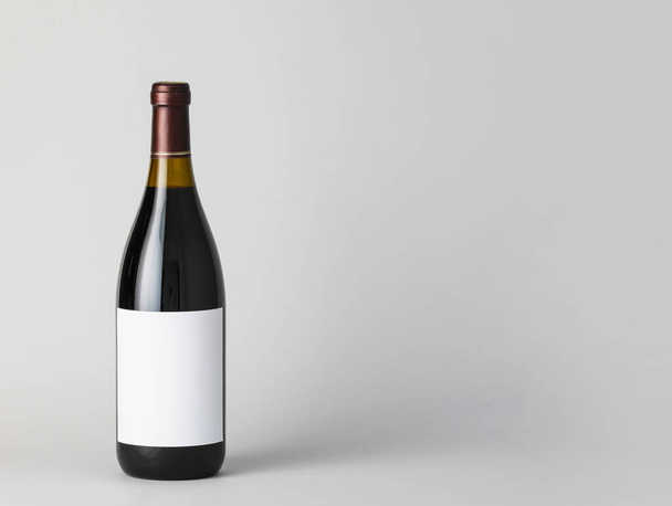 Flasche Wein mit leerem Etikett auf hellem Hintergrund. Mockup für Design - Foto, Bild