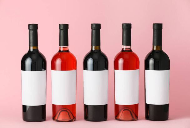 Μπουκάλια κρασί με κενές ετικέτες στο φόντο χρώμα. Mockup για σχεδιασμό - Φωτογραφία, εικόνα