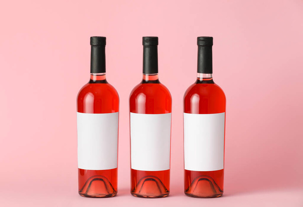Weinflaschen mit leeren Etiketten auf farbigem Hintergrund. Mockup für Design - Foto, Bild