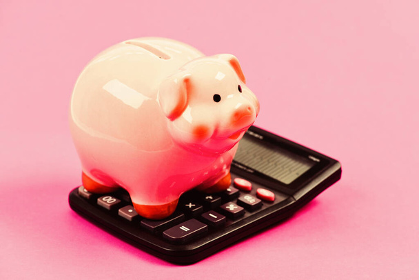 Exchange rates. Economics and business administration. Piggy bank money savings. Piggy bank pink pig and calculator. Credit debt concept. Economics and profit management. Economics and finance - Fotó, kép