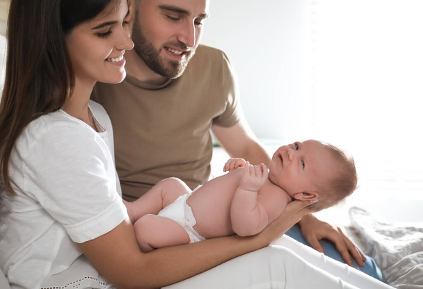 Happy couple with their newborn baby at home - Foto, afbeelding