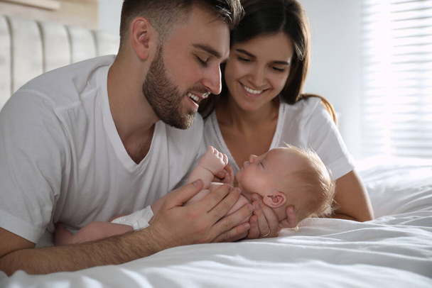 Happy couple with their newborn baby at home - Fotografie, Obrázek