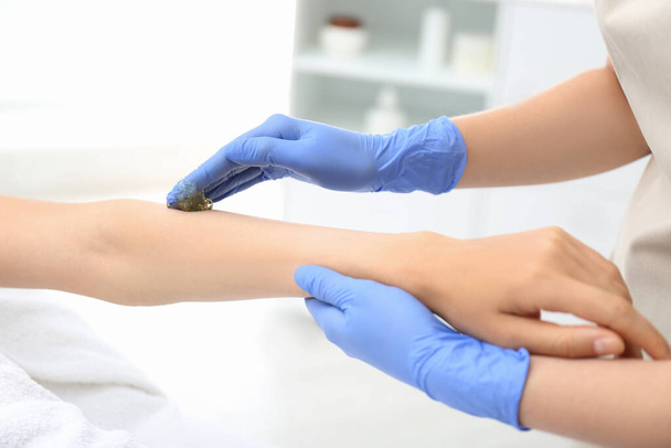 Woman getting wax epilation of arm in salon, closeup - Foto, Bild