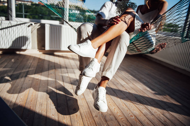 Пара влюбленных веселится на сетке гамака, на солнце - Фото, изображение