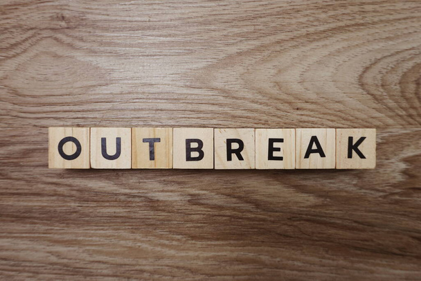 Outbreak alphabet letter on wooden background - Photo, Image