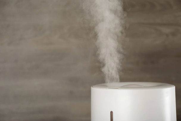 Modern air humidifier on wooden background, closeup. Space for text - Fotografie, Obrázek