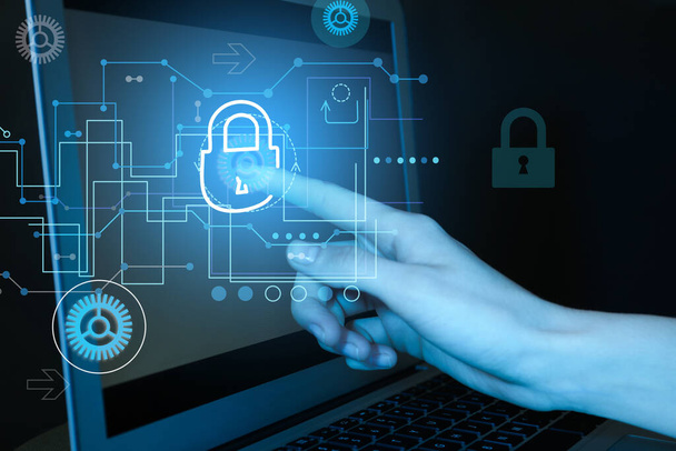 Cyber attack protection. Woman touching lock icon on laptop screen, closeup - Fotó, kép