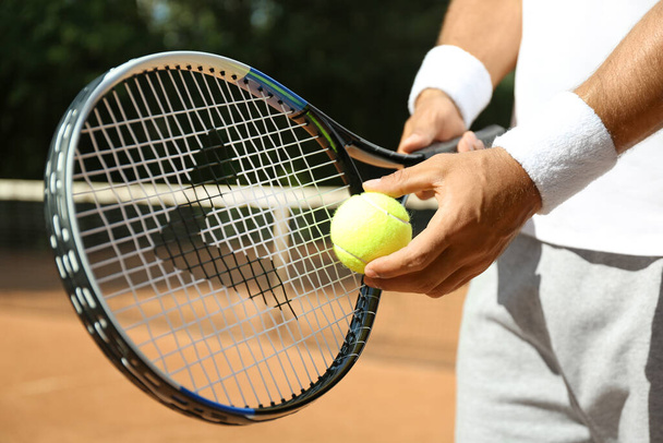 Sportsman preparing to serve tennis ball at court, closeup - Foto, Bild