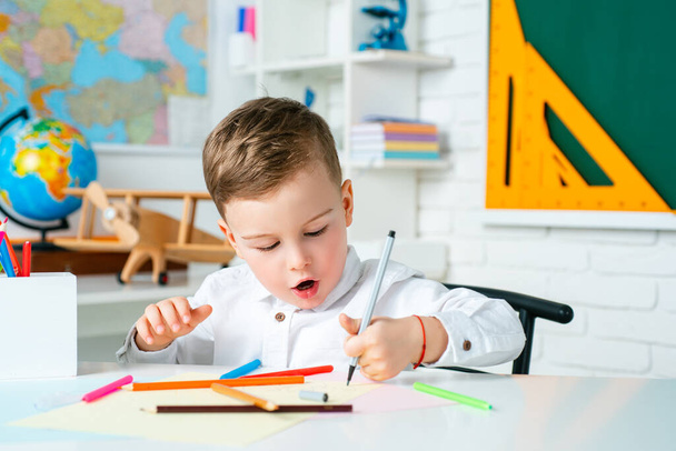 Cute kid at home or daycare. Child studying from home. Elementary school learning and kids concept. - Foto, Imagem