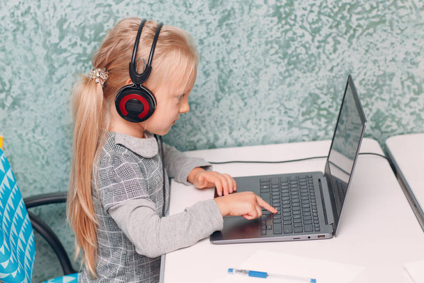 Jeune étudiante petite fille imprimant clavier ordinateur portable apprentissage et préparation à la rentrée scolaire - Photo, image