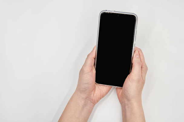 Mockup smartphone leeg scherm in vrouwelijke handen op lichte achtergrond. Sluitingsdatum. - Foto, afbeelding