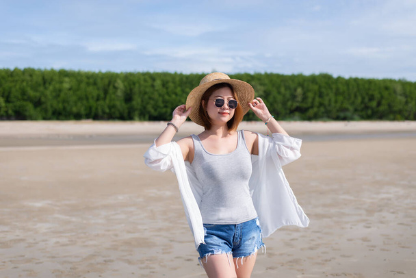 Happy traveller asian woman wearing hat and glasses,Enjoying and relaxing at the beach - Photo, image