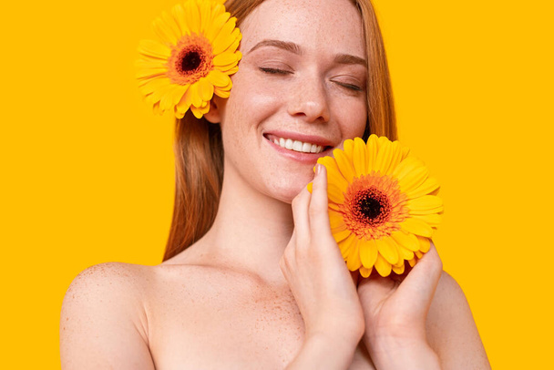 Delighted ginger woman with flowers - Φωτογραφία, εικόνα
