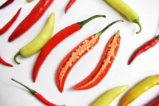 Červené chilli, zelené žluté chilli papričky plátky / řez / polovina izolované v bílém pozadí, flay ležel, horní pohled, thajské chilli v bílém stole - Fotografie, Obrázek