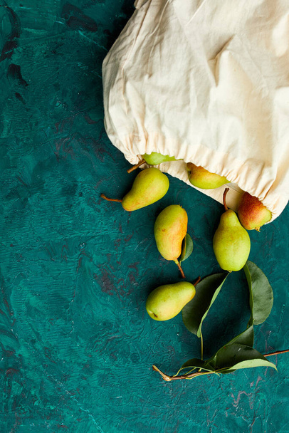 Fresh ripe fruits pears in string reusable shopping eco bag on a green background, grocery concept, Flat lay, Eco friendly, autumn harvest. Copy space. - Photo, Image