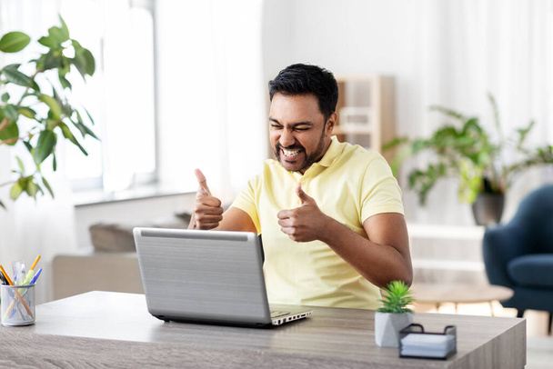 happy indian man with laptop at home office - Фото, зображення