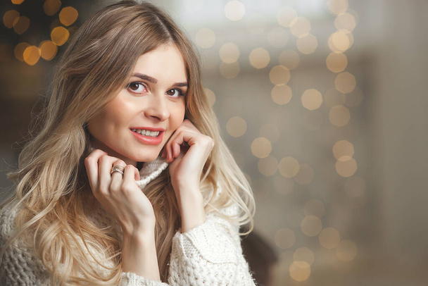 Nahaufnahme Porträt der attraktiven blonden jungen Frau auf weihnachtlichem Hintergrund - Foto, Bild