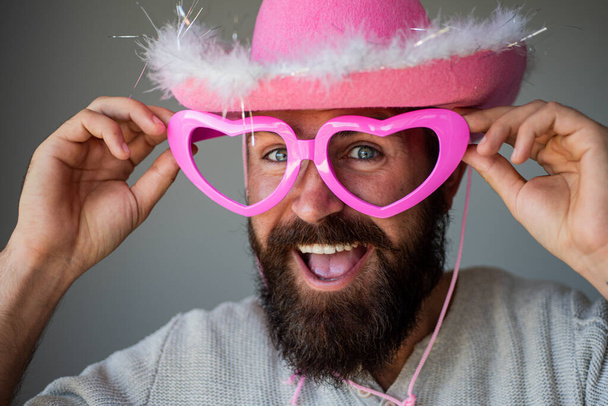 Fun cowboy. Happy man with funny pink glasses smile face closeup. Handsome smiling young guy. Positive human facial expressions and emotions. - Fotó, kép