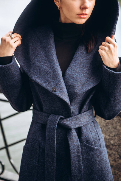Detail of a female coat close-up. Young adult girl in an elegant coat outdoors. Promotional women's coat. Young fashionable brunette woman in a stylish woolen autumn and spring coat. - Fotografie, Obrázek