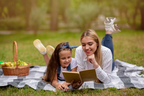 Mère et fille lecture livre profiter week-end ensemble dans le parc - Photo, image