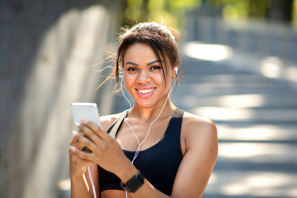 Closeup of happy african woman listening to music while jogging - Foto, Bild