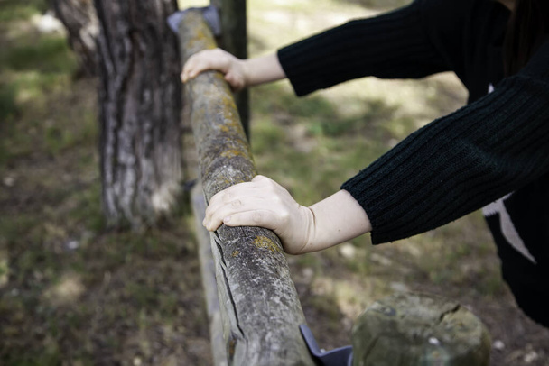 Kezek megragad egy rönk fa, részlet a pihenés a természetben - Fotó, kép