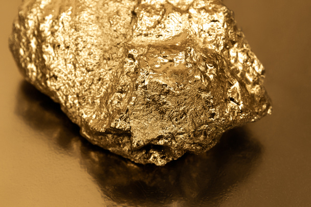 Goldstein auf goldenem Hintergrund. - Foto, Bild
