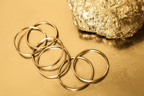 Gold rings on a gold background. Gold stone. - Photo, Image