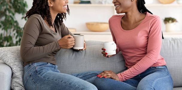Обрізана з двох африканських дам, які розмовляють і п'ють каву
 - Фото, зображення