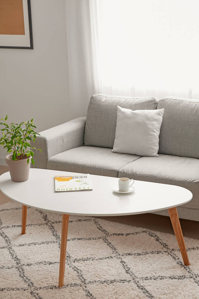 Stilvolle Einrichtung des Wohnzimmers mit Tisch und Sofa - Foto, Bild