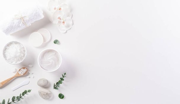 Cosmetic bottle containers, skin cream with flowers. Natural beauty and spa concept, Top view on white table background. - Photo, Image