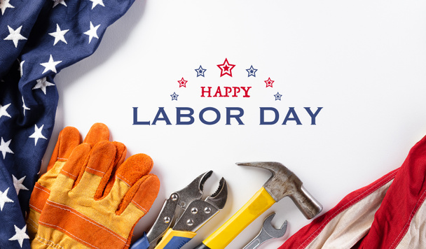 Happy Labor day concept. American flag with different construction tools on white background, with copy space for text. - Photo, Image