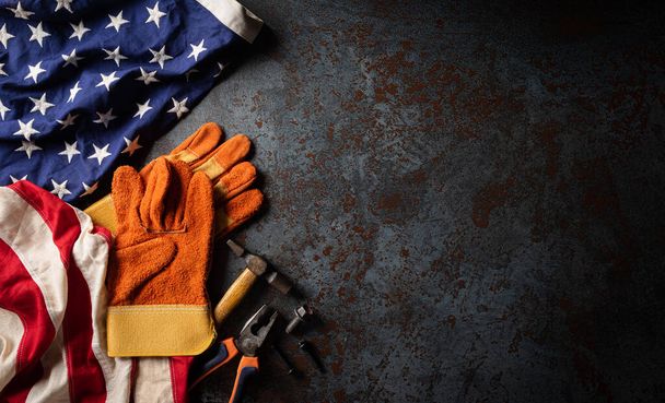 Happy Labor Day Konzept. Amerikanische Flagge mit verschiedenen Bauwerkzeugen auf dunklem Steinhintergrund, mit Kopierplatz für Text. - Foto, Bild