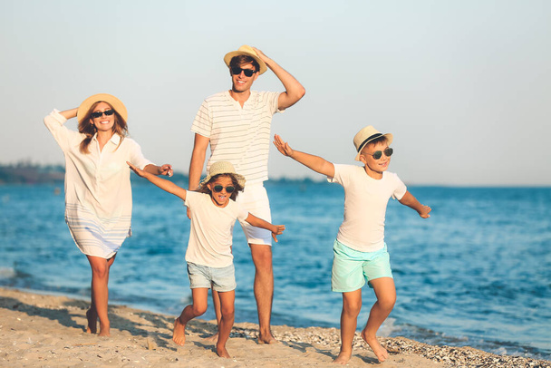 Ευτυχισμένη οικογένεια στην παραλία της θάλασσας στο θέρετρο - Φωτογραφία, εικόνα