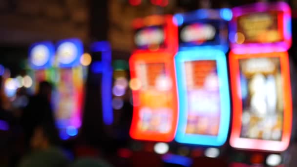 Defocused slot machines glow in casino on fabulous Las Vegas Strip, USA. Blurred gambling jackpot slots in hotel near Fremont street. Illuminated neon fruit machine for risk money playing and betting - Footage, Video
