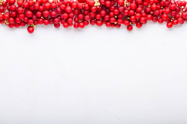 Schisandra chinensis vagy öt ízű bogyó. Friss piros érett bogyók fehér háttérrel. Első látásra. Másold a helyet. Élelmiszer-háttér. - Fotó, kép