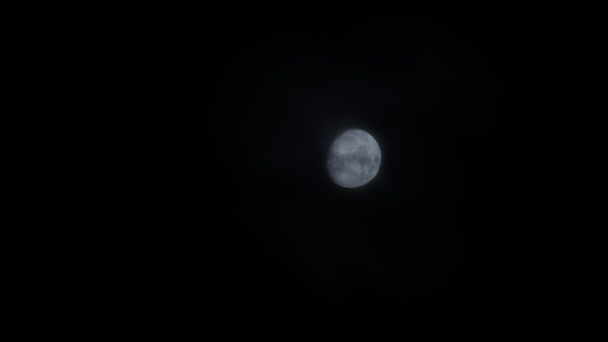 Ciemne, straszne, malownicze tło jasnej pełni księżyca świecącej na nocnym niebie z szybkimi couds pochmurno przewracającymi się. Halloween blask księżyca gwiaździsty - Materiał filmowy, wideo