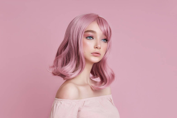 Portrait of a sexy young woman with pink hair. Perfect hairstyle and hair coloring. Girl with beautiful blue eyes and long pink hair - Фото, изображение