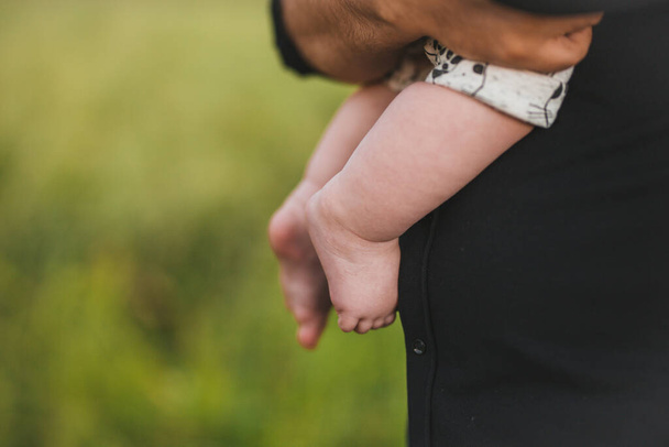 Newborn baby in the arms of parents in the open air. - Photo, Image