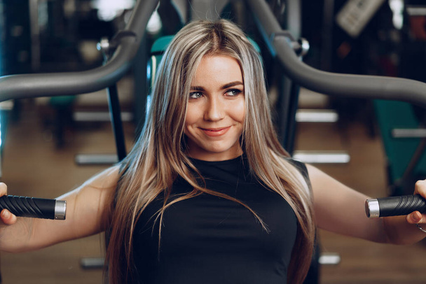 jong blond vrouw fitness coach doen handen workout - Foto, afbeelding