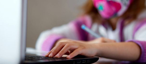 Невпізнавана дівчина, школярка, вчиться вдома з зошитом і робить домашнє завдання. Навчання на відстані онлайн. Coronavirus Home School концепт, карантин. - Фото, зображення