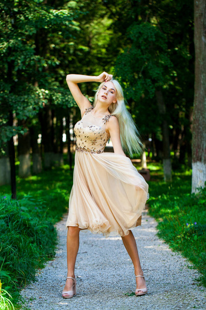 Full body portrait of a young beautiful blonde woman in beige dress, summer park outdoor - Fotografie, Obrázek