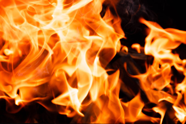 Textura de una llama de fuego sobre un fondo negro. fuego ardiente en un primer plano de estufa - Foto, imagen